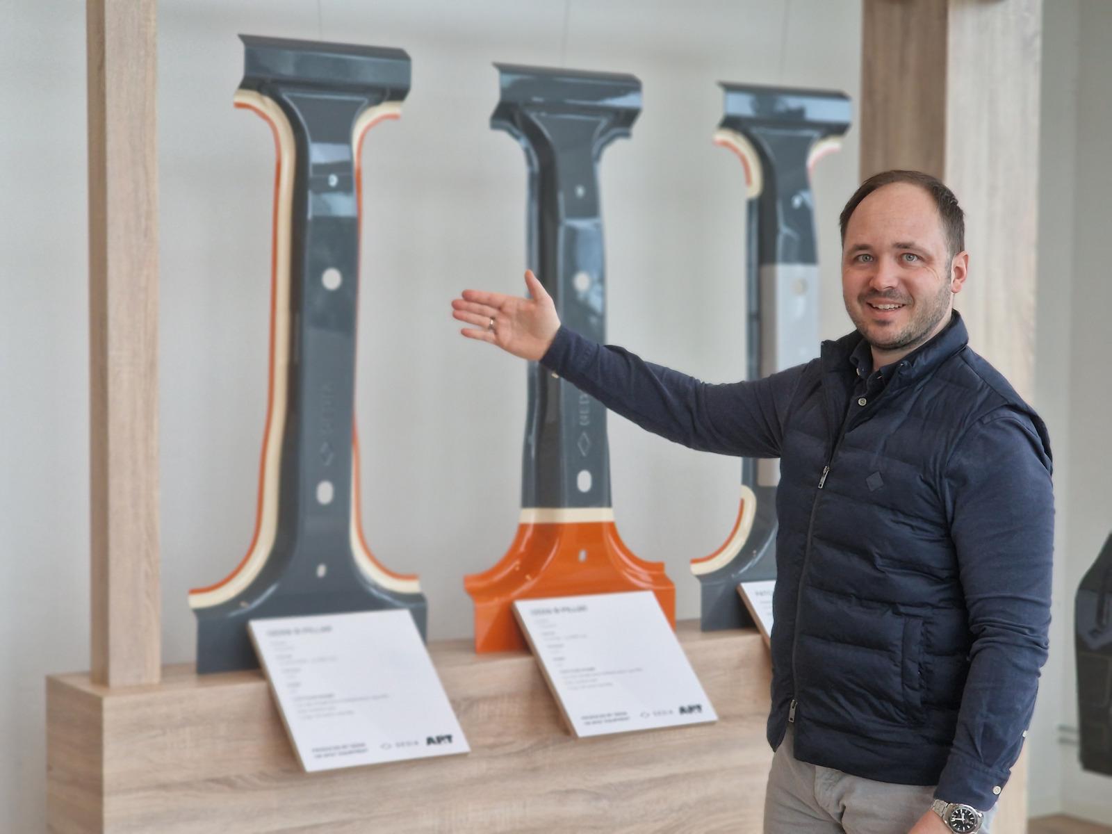 Dr. Christian Koroschetz, Head of Products, Business Development and Marketing at AP&T, with three B-pillars produced using TemperBox technology, developed jointly by AP&T and GEDIA. The technology enables hard and soft zones to be combined within a single component, offering greater design freedom and improved crash performance.